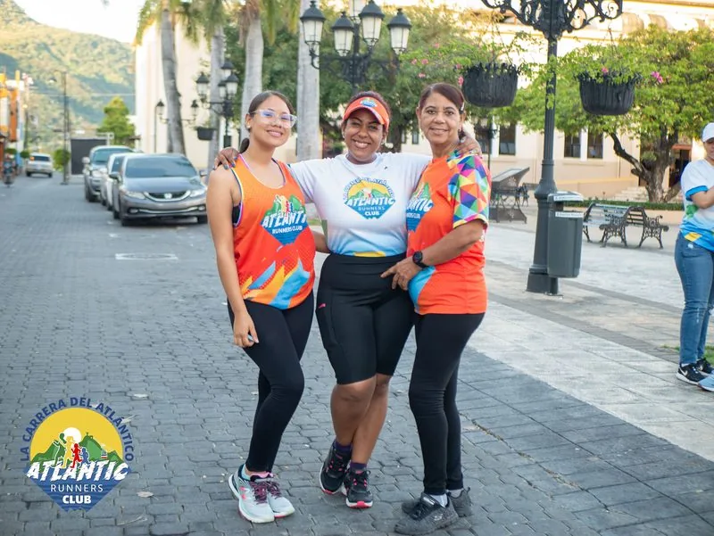 Tres atletas posando juntas en una calle adoquinada del centro de Puerto Plata.