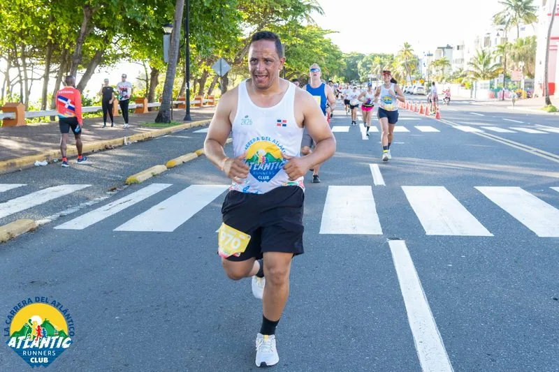 Un corredor en una carrera con un atuendo deportivo y un número de participación visible.